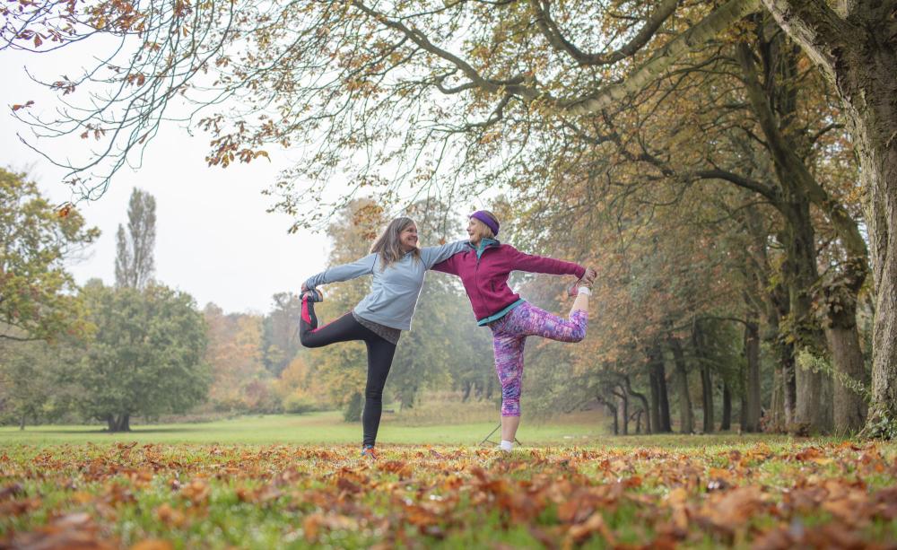Vegans in yoga stretches in an autumn park