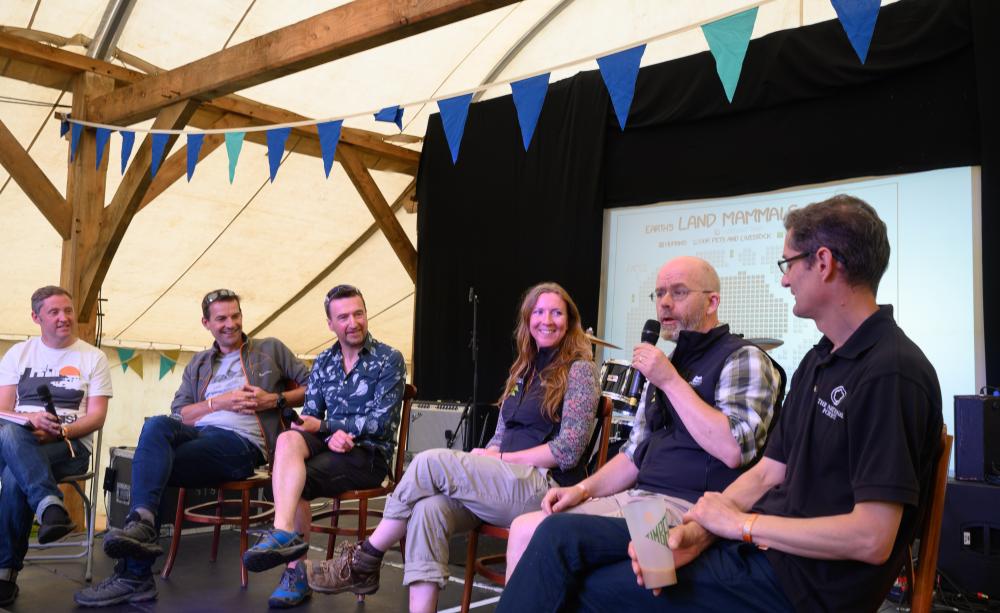 Six speakers on stage for a panel discussion.