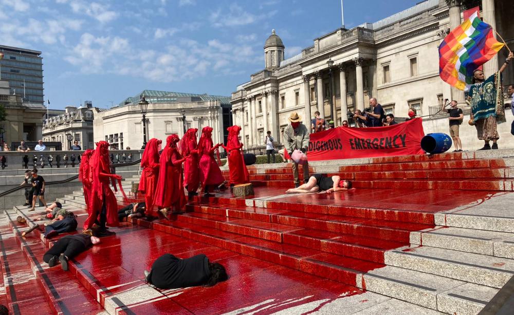 Extinction Rebellion pour blood on the steps of Trafalgar Square to highlight the crisis in Brazil