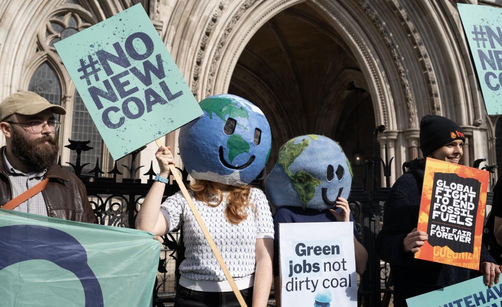 Campaigners with placards celebrated their victory outside the High Court