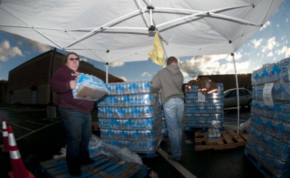 Volunteers Bethany Whisman and Blake Kenney hand out bottled water on Jan. 11, 2014, at Poca High School, W.Va. Photo: Staff Sgt. De-Juan Haley / National Guard via Flickr.com.