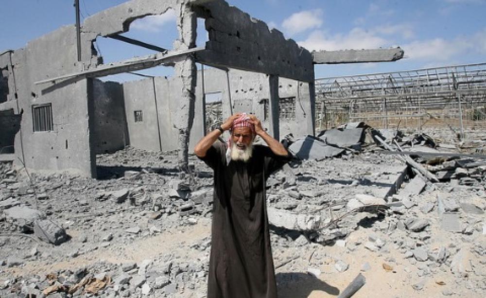 Could his loss be Israel's gain? A destroyed house in Gaza and its distraught owner, 22nd July 2014. Photo: Mohammed Al Baba / Oxfam International via Flickr.
