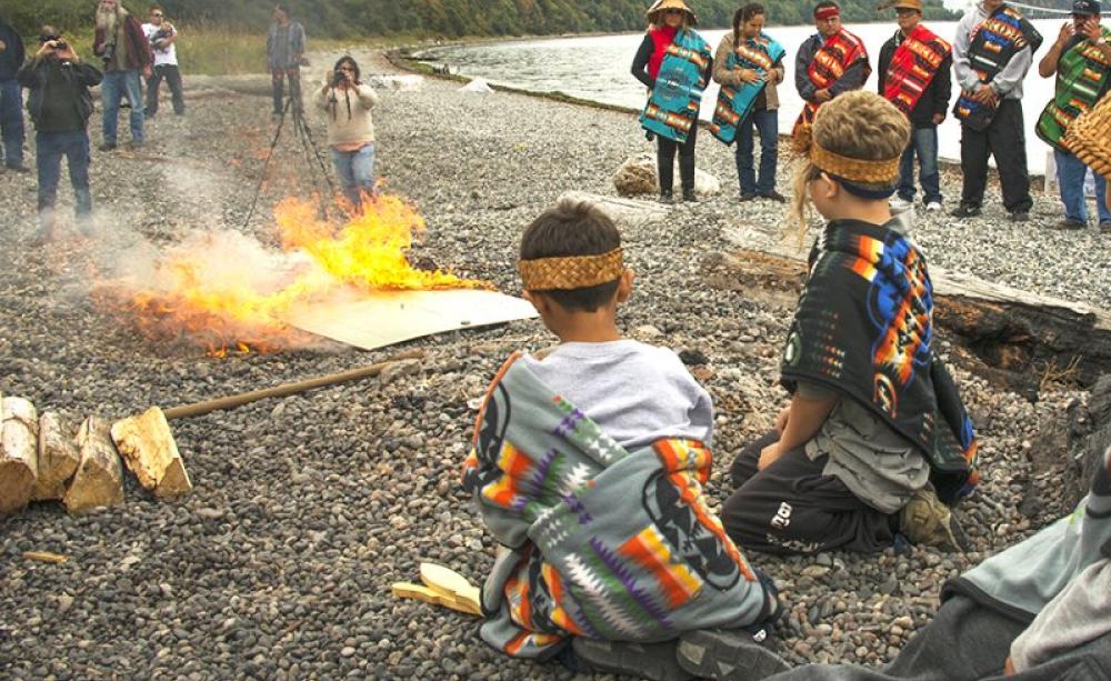 Young participants observing the flames at the symbolic check burning ceremony. Photo: Paul Anderson / EarthJustice.