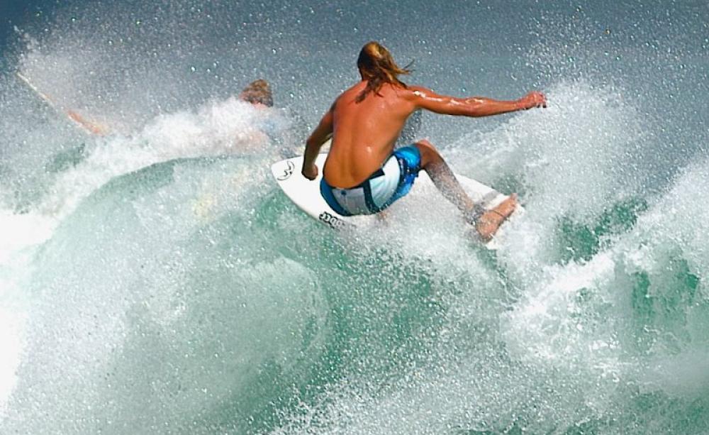 Surfing at Noosa Beach, Australia. To avoid shark attack, keep out of the water at dawn and dusk, and avoid turbid estuaries. Even sharks can make mistakes. Photo: m.maddo via Flickr (CC BY).