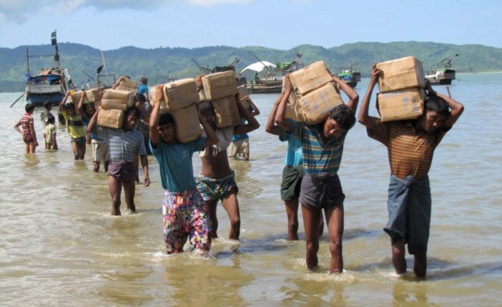 Internally displaced Rohingya residents of a camp near Sittwe carrying vital supplies of rice and cooking oil. Photo: Mathias Eick, EU/ECHO, Rakhine State, Burma, September 2013.