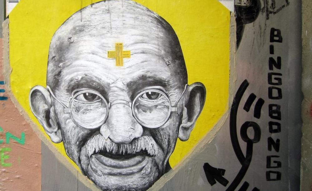 Mahatma Gandhi remains a potent symbol of freedom from the oppression of colonialism and overweening corporate power. Photo: wall in Berlin by Marius Watz via Flickr (CC BY-NC-SA).