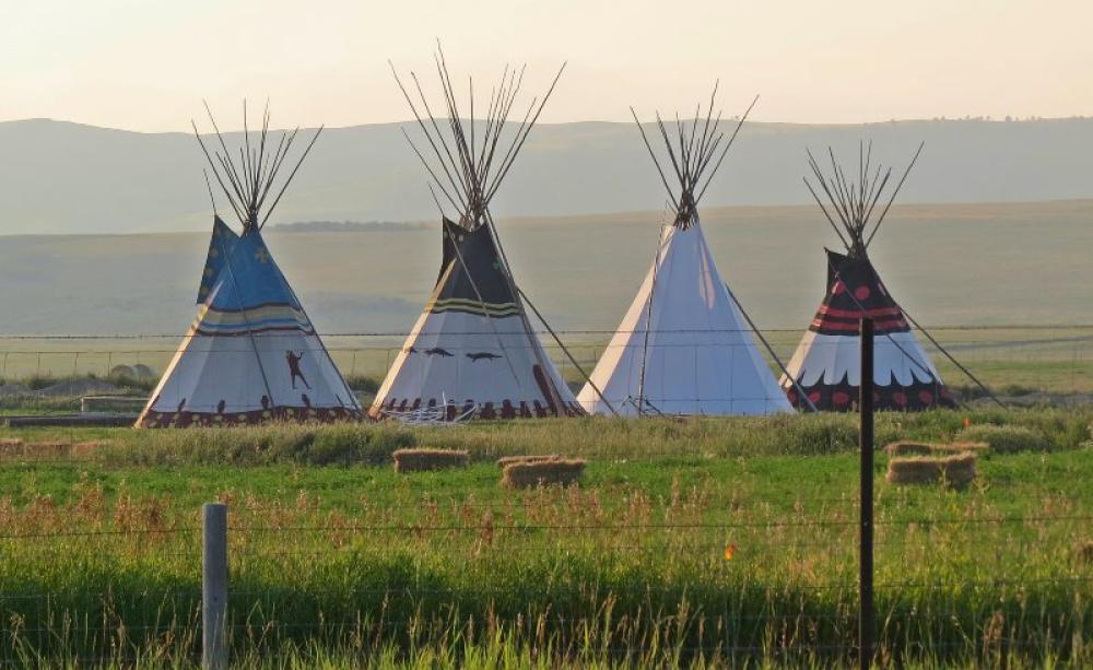 Fenced with barbed wire: Blackfeed Indian tipis near the Glacier Nation Park, where the NPS is excluding the Indians from their rightful access to the Park and its resources, in clear breach of an 1895 contract. Photo: Bon via Flickr (CC BY-NC-ND).