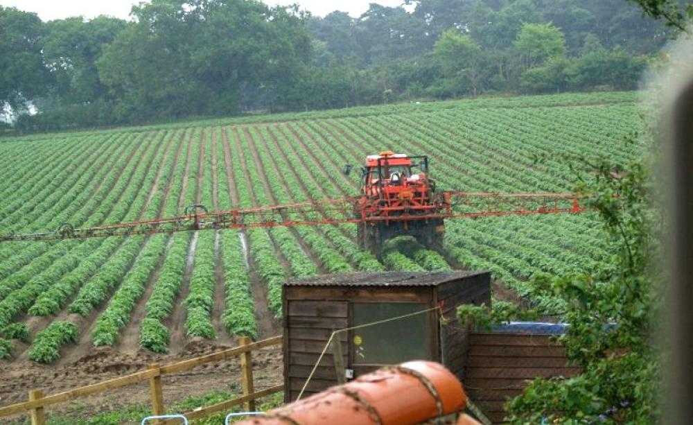 Pesticide spraying taking place just over the garden fence of a British home. Photo: UK Pesticides Campaign.