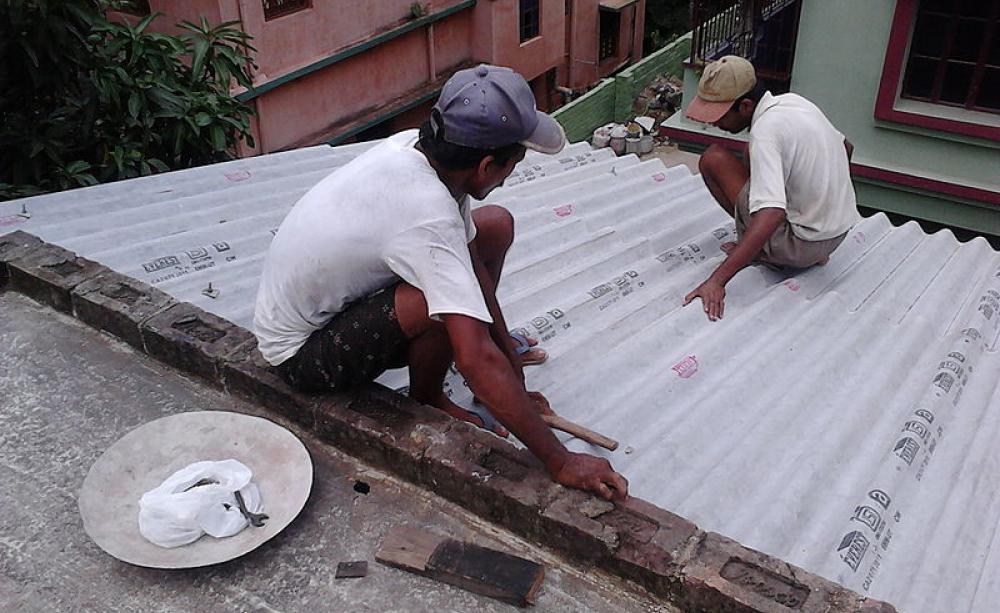 A corrugated asbestos roof is installed on a roof in India. The low cost material is still used regularly in developing countries (c) Biswarup Ganguly
