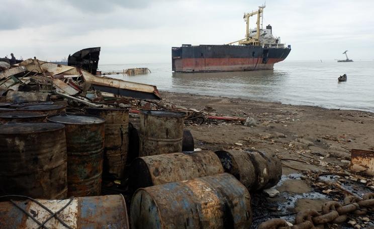 Shipbreaking yard in Bangladesh with pollution and half of a ship