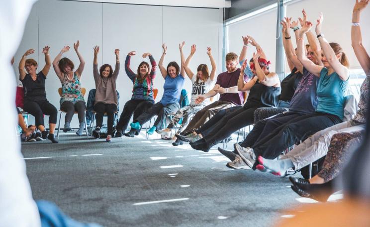 People sitting in a circle with arms in the air
