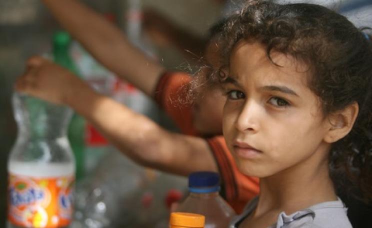Children in Rafah collect water from one of the working public taps, 13th July 2014. But with the bombing of water infrastructure and Gaza's only power station, it's unlikely to be working today. Photo: Oxfam International via Flickr.
