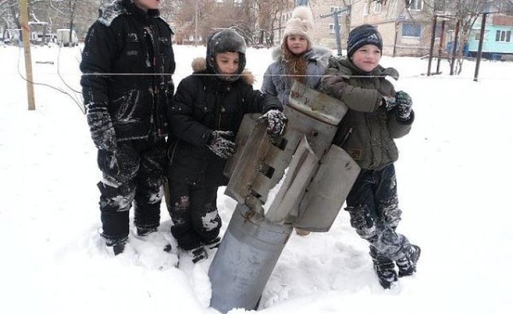 Children gather around an unexploded shell fired by Kiev forces into a residential area of Eastern Ukraine. Photo: Colonel Cassad (cassad-eng.livejournal.com).