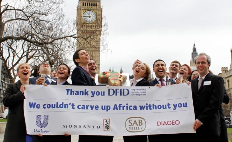 Global Justice Now supporters dressed as business people from Monsanto, Diageo, SABMiller and Unilever campaigning against the Department for International Development's involvement with the 'New Alliance'. Photo: Global Justice Now via Flickr (CC BY 2.0)