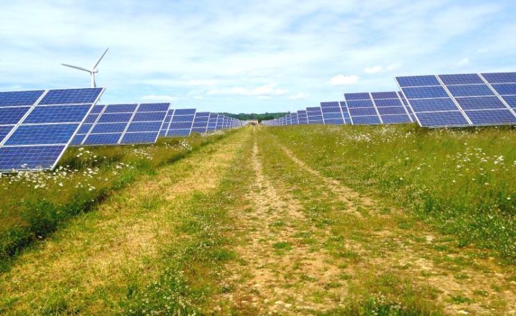 Solar panels and wind turbine at Westmill Farm, Oxfordshire, which hosts several community financed renewable energy cooperatives. Photo: Richard Peat via Flickr (CC BY-NC-ND).